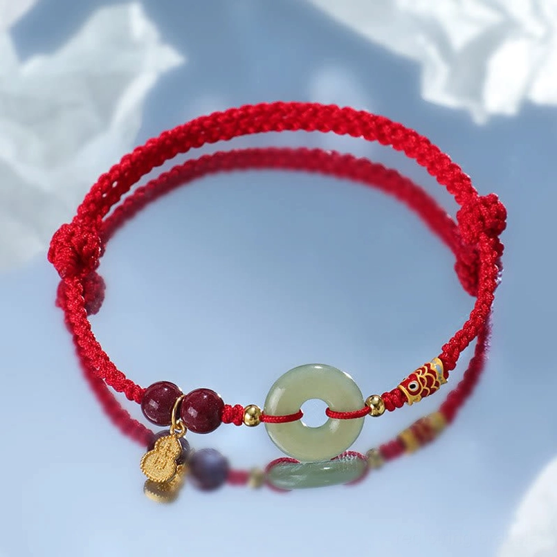 Red string protection bracelet Hetian Jade cinnabar on frosted blue background