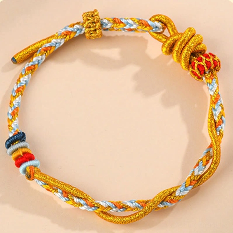 Handmade red string protection bracelet with gold thread and colorful bead accents – oblique angle