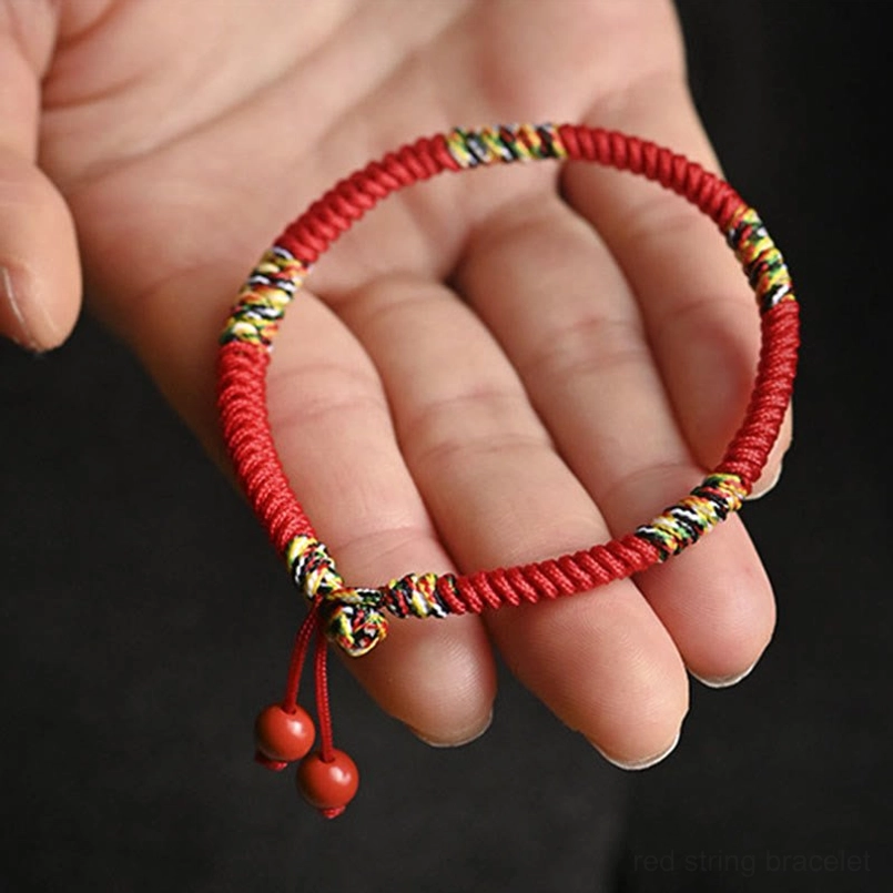 King kong knot bracelet worn on wrist with book background showing spiritual protection bracelet in use