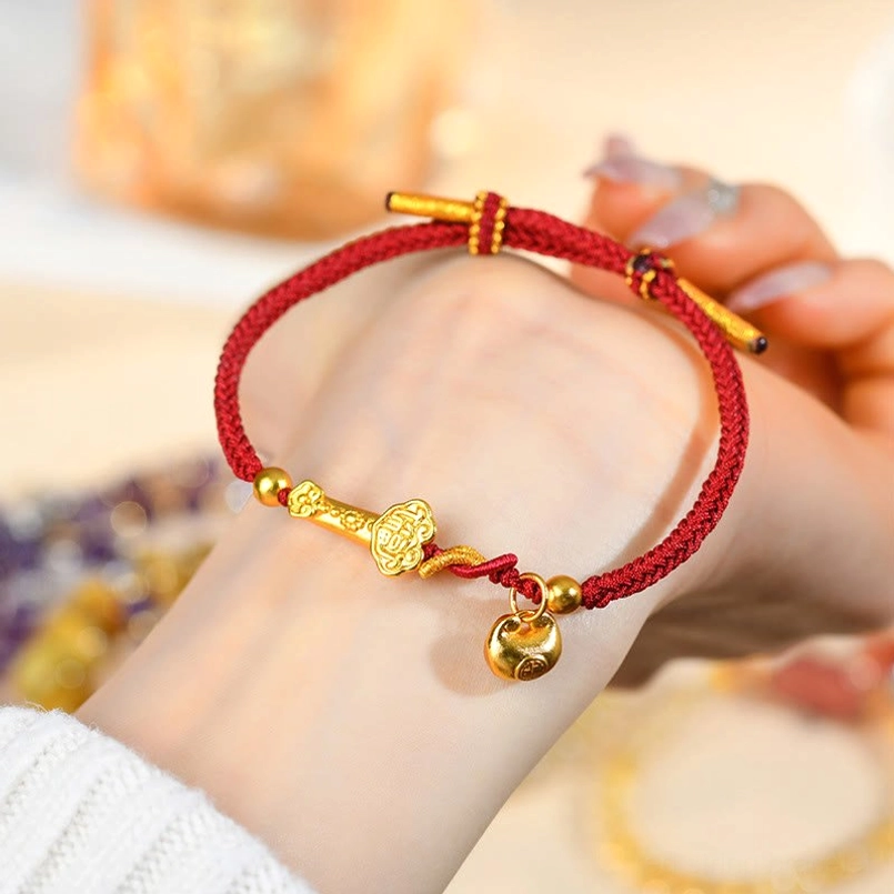 Red string Ruyi bracelet worn on wrist showing adjustable fit and gold charms