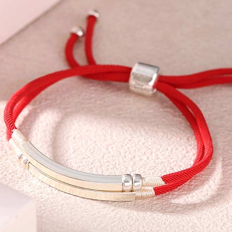 Close-up top view of red string silver bar bracelet showing thick braided cord and layered sterling silver accents