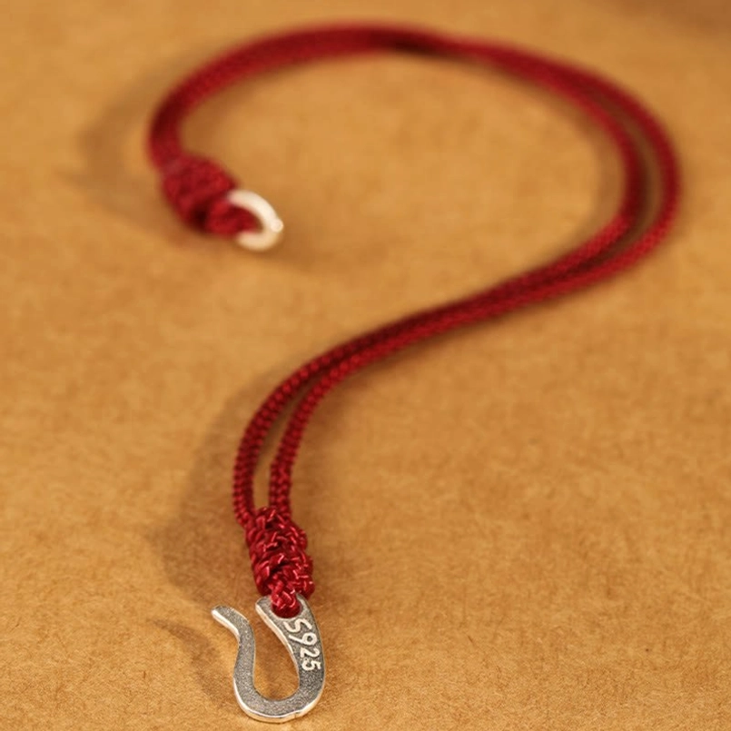Unfastened 925 sterling silver red string bracelet showing dual hook clasps