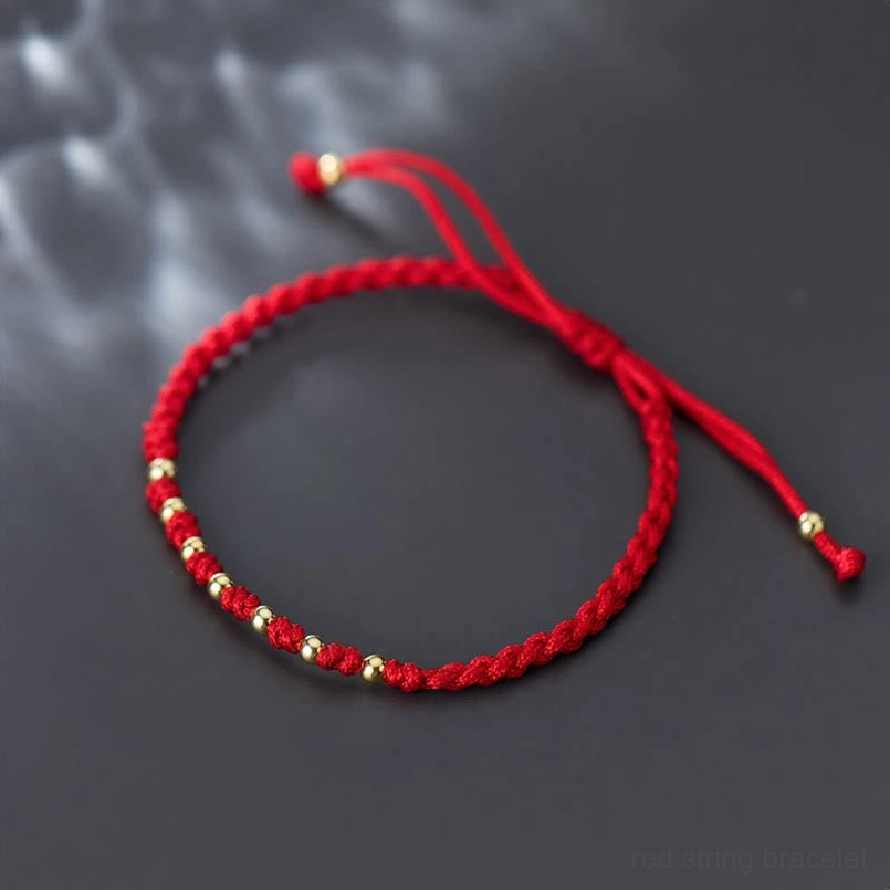 925 sterling silver red string protection bracelet overhead product shot dark background