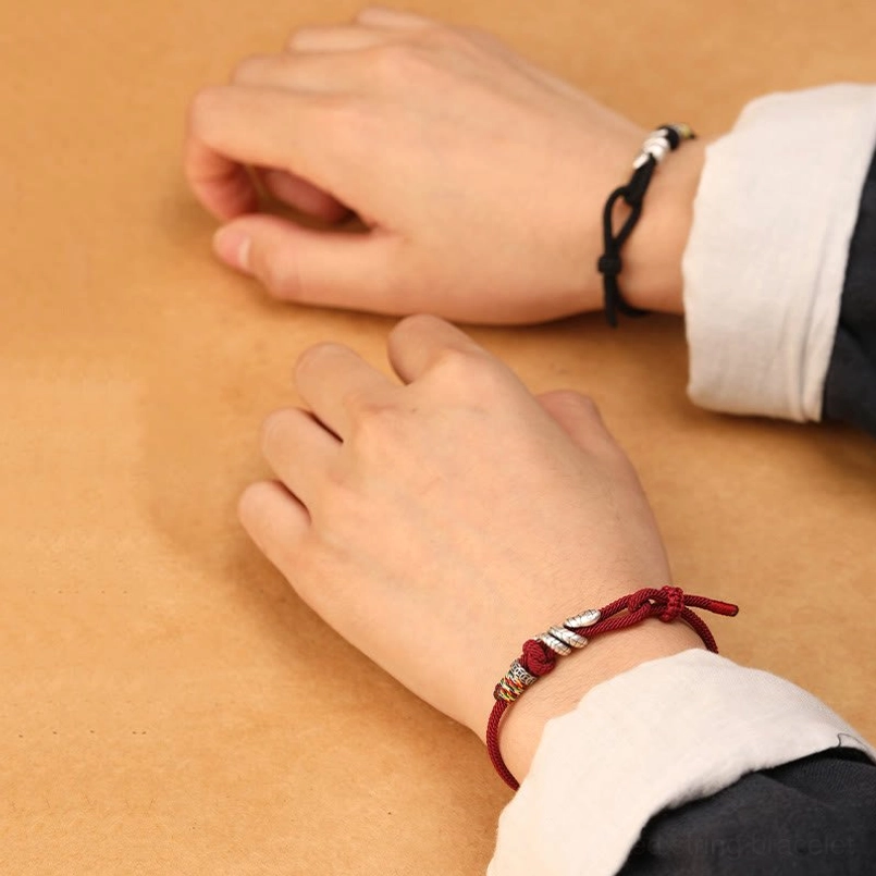 Red string snake bracelet featuring adjustable slip knot and protective silver serpent symbol