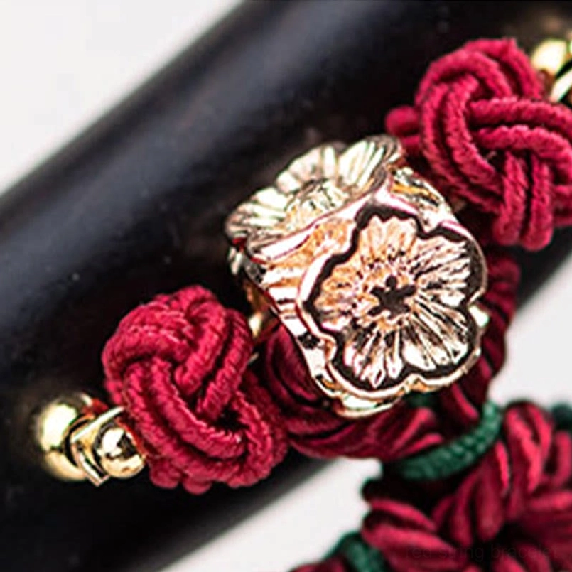 Red string tassel hairpin close-up showing silk quality and detail