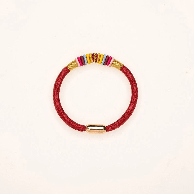 Red string Tibetan bracelet showing intricate King Kong Knot weaving and magnetic closure
