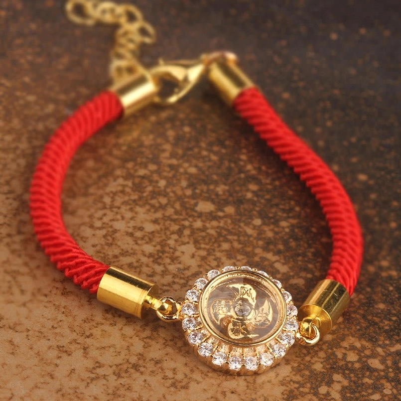 Red cord feng shui bracelet front view with lobster clasp extension chain and rotating copper windmill charm