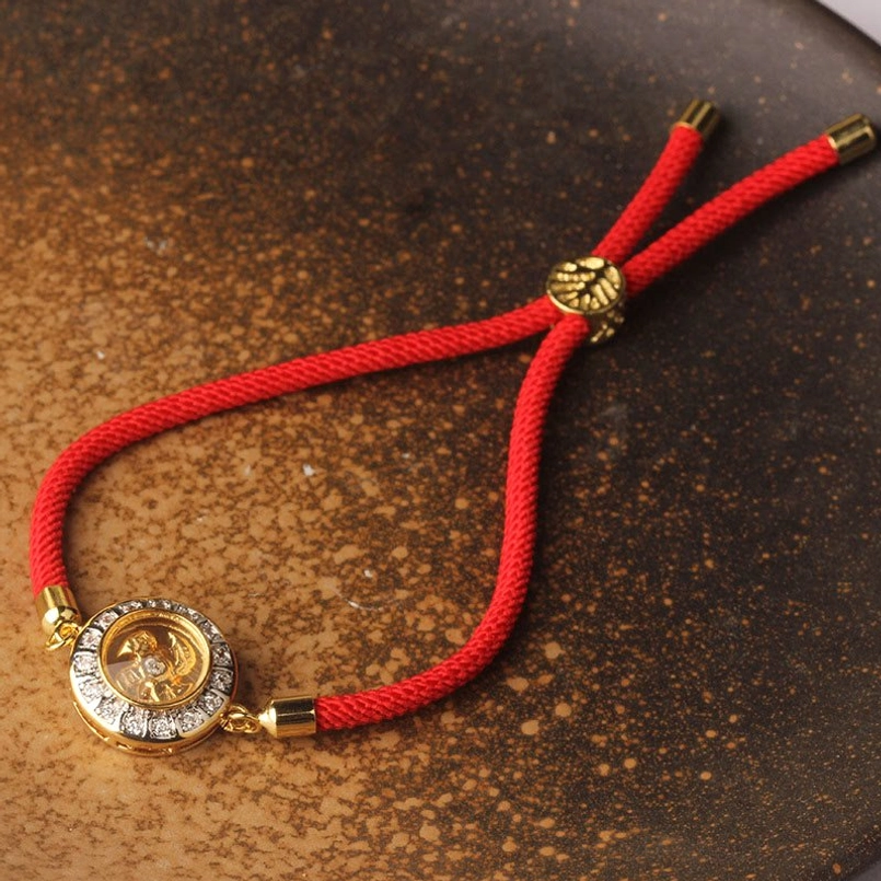 Rotating windmill red string bracelet styled flat lay with lifestyle accessories