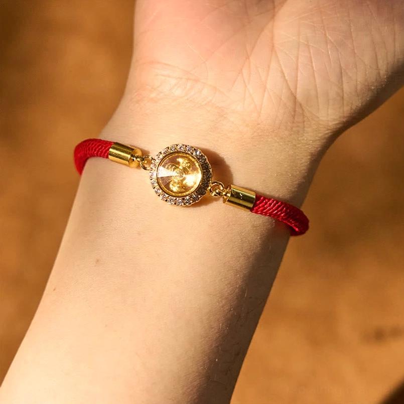 Red string feng shui protection bracelet worn on wrist showing compact fit and elegant gold charm design
