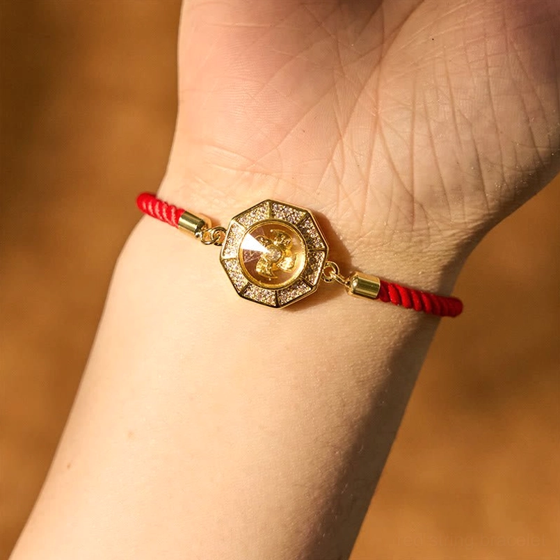 Adjustable feng shui red string windmill bracelet worn on wrist showing rotatable octagonal copper charm and fit