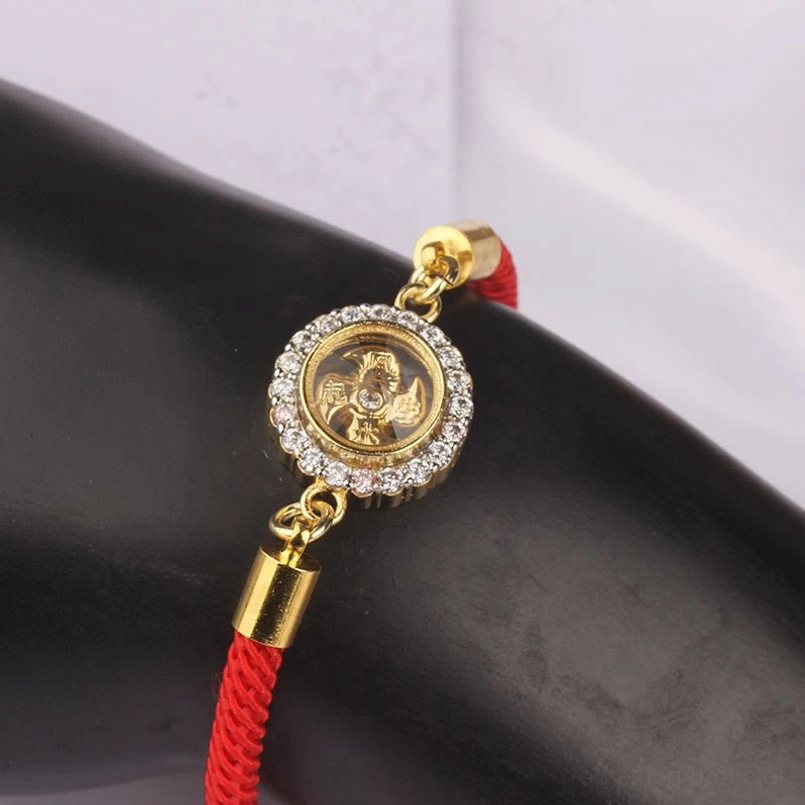 Red string feng shui protection bracelet with rotatable windmill charm worn on model hand showcasing fit