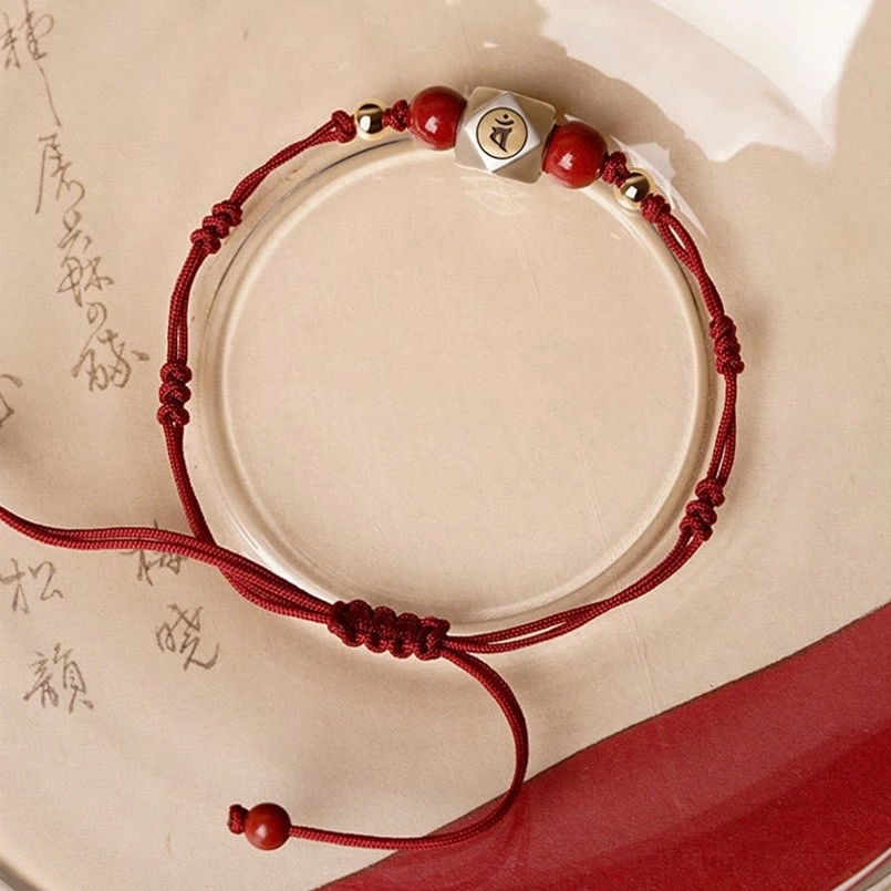 Red woven zodiac bracelet with silver charm bead and adjustable tie design