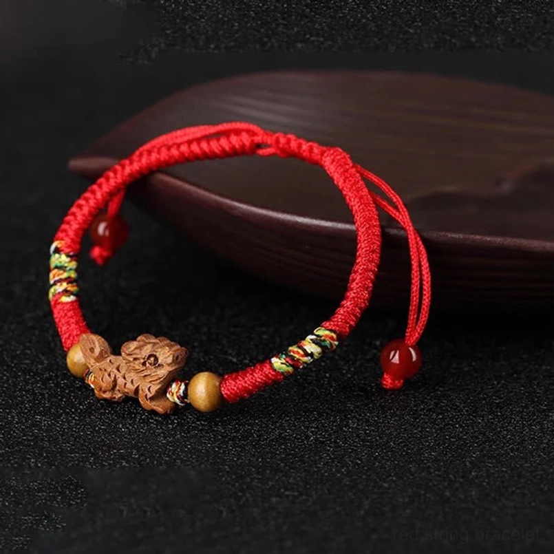Red string zodiac bracelet close-up detail view