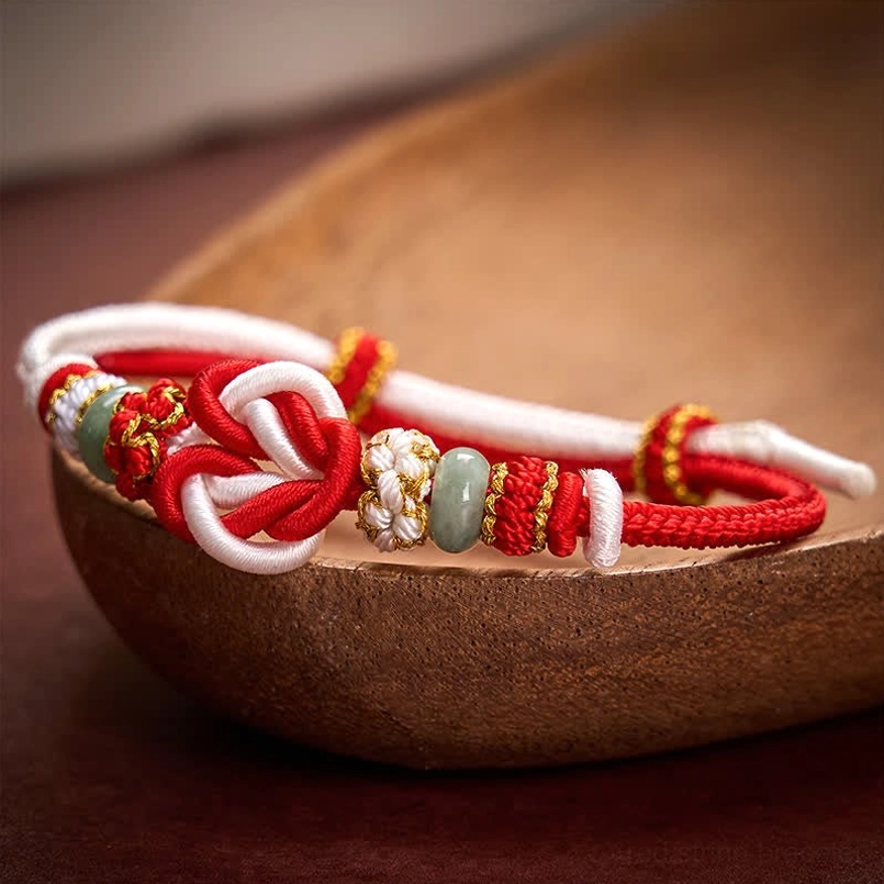 Red white heart knot bracelet close-up showing dual-color cord and jade beads
