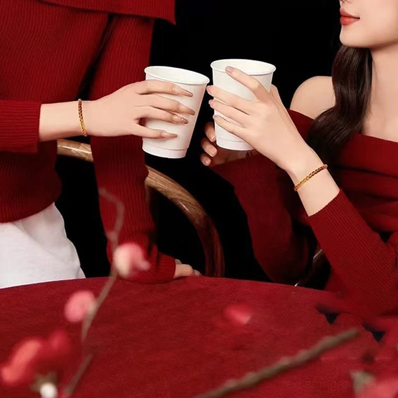 Minimalist thin red and yellow woven bracelet worn casually on female wrist at dining table