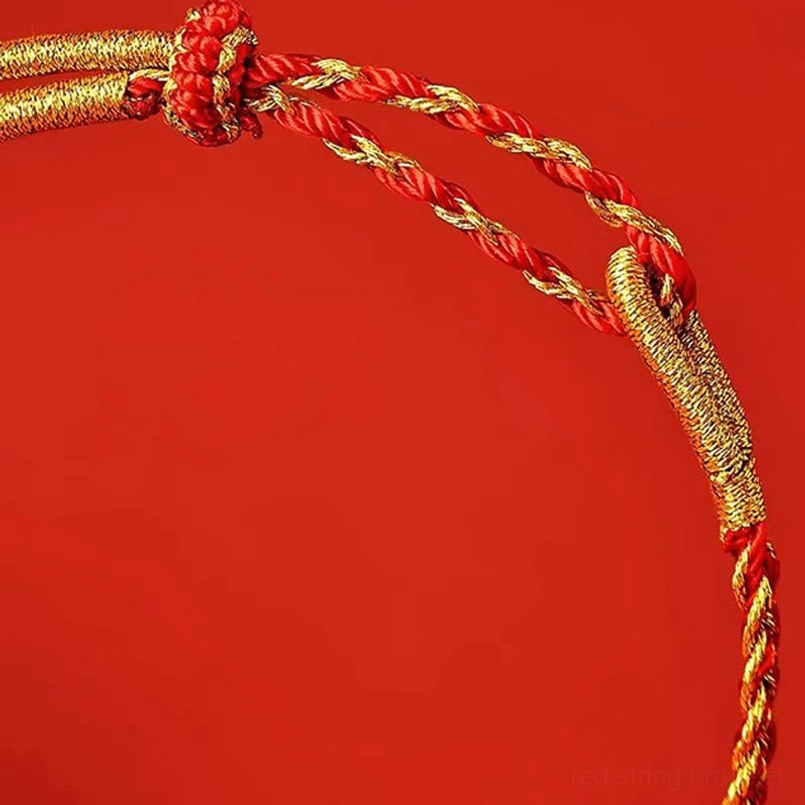 Extreme close-up of red and yellow bracelet knot and braided weave texture with gold thread accents