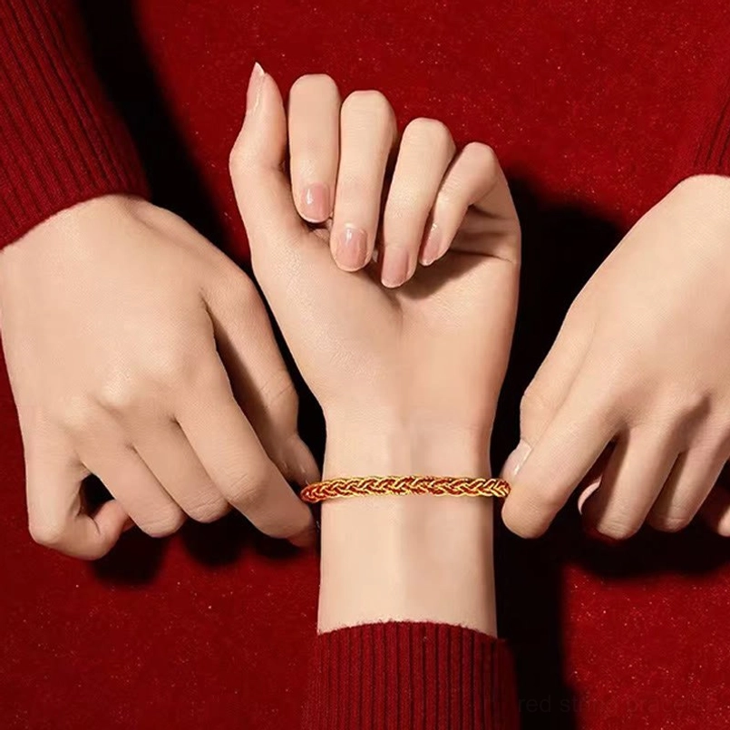 Red and yellow luck bracelet being worn on wrist, demonstrating comfortable fit and adjustable design