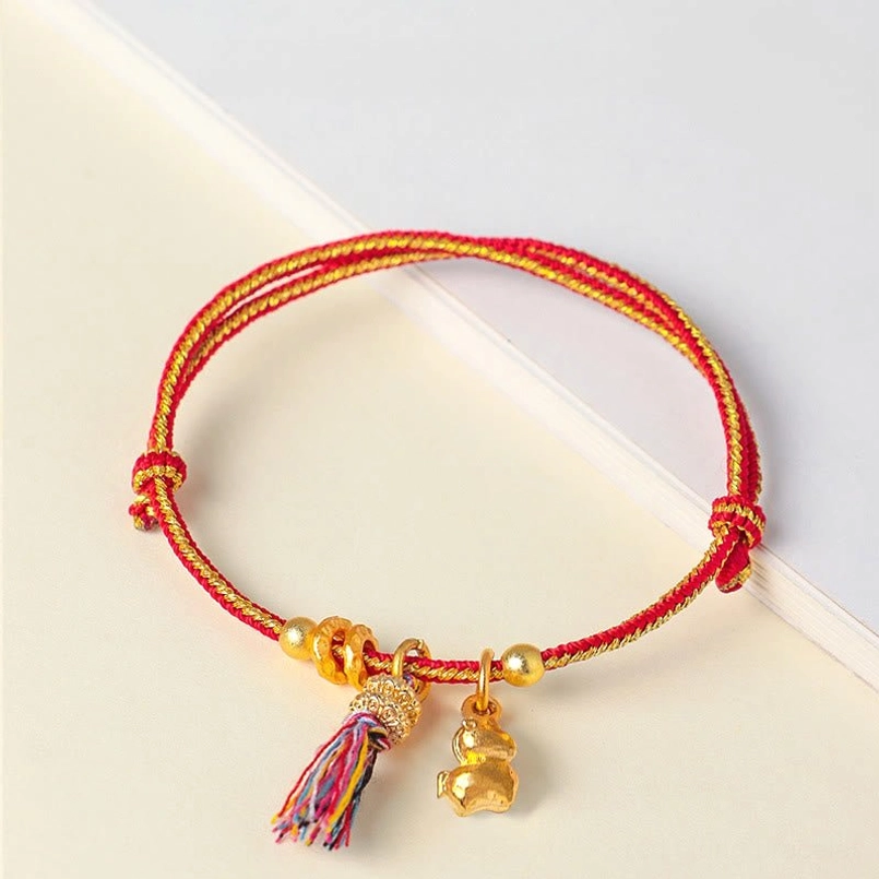 Red and yellow string horse charm tassel bracelet flat lay