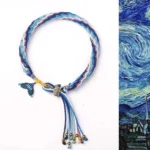Hand-woven reincarnation knot bracelet with blue-purple fishtail charm and metal bead tassel on white background