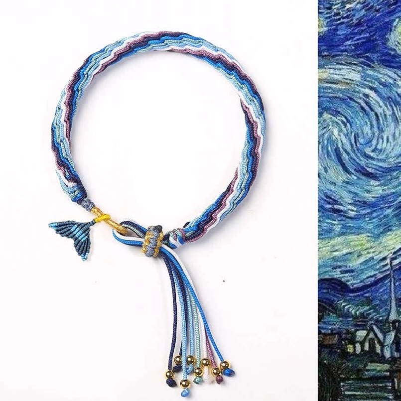Hand-woven reincarnation knot bracelet with blue-purple fishtail charm and metal bead tassel on white background