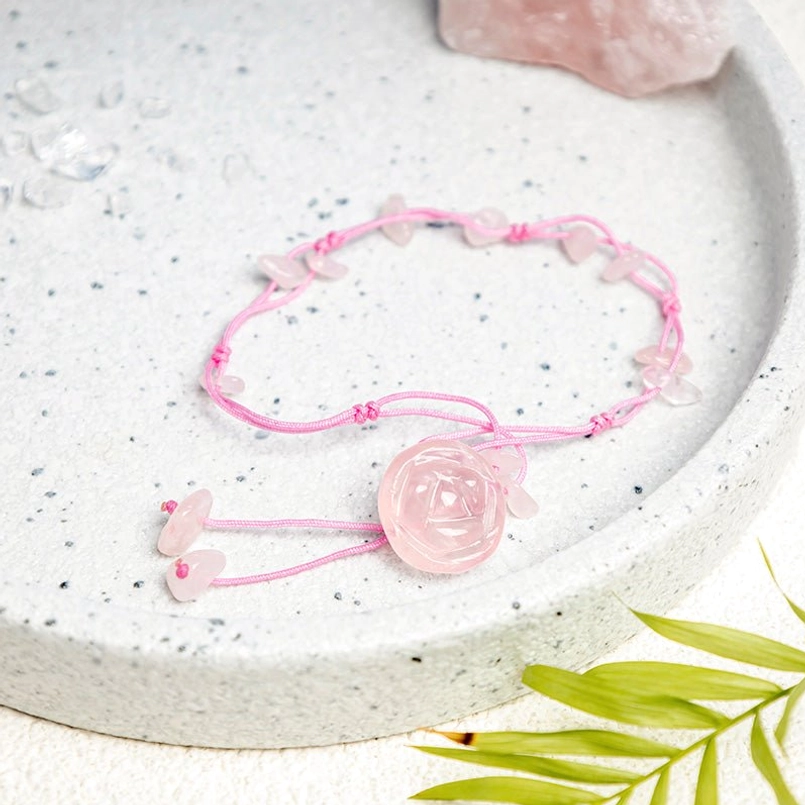 Rose quartz crystal healing anklet with pink cord and dangling rose quartz pieces on ceramic tray