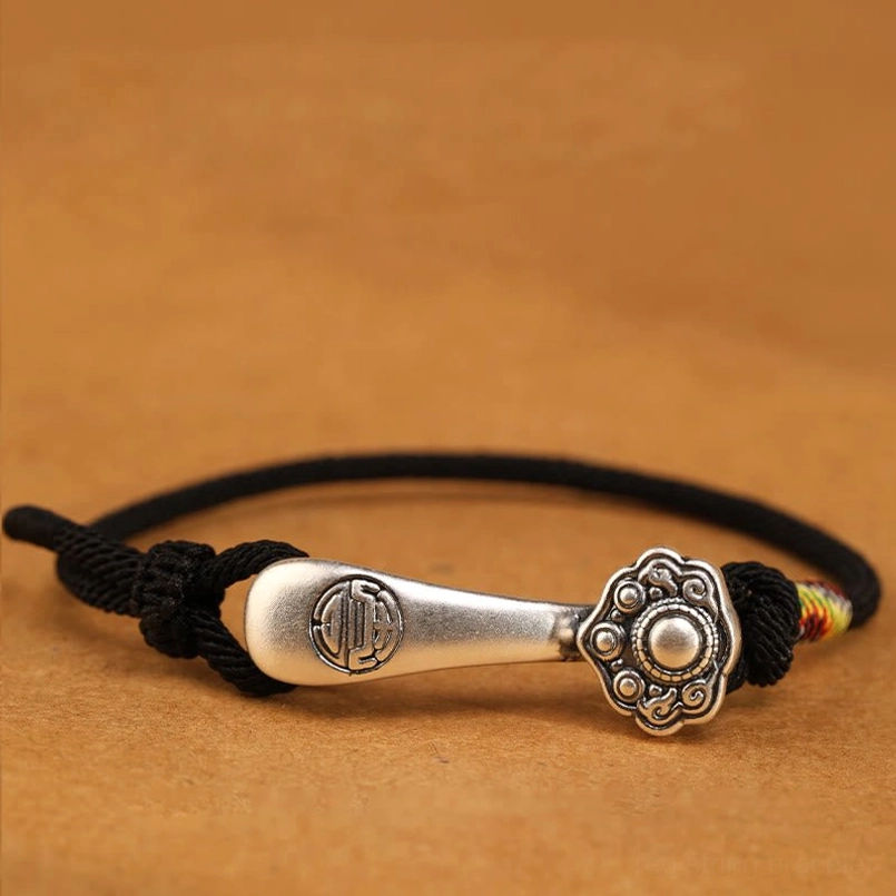 Black cord Ruyi stick protection bracelet with sterling silver pendant - overhead close-up displaying black braided rope and multicolor detail