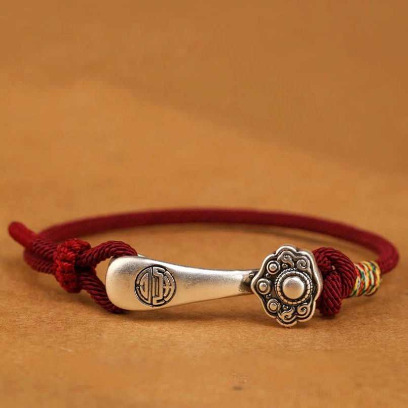 Dark red Ruyi stick bracelet with sterling silver charm - side profile view displaying engraved silver pendant and braided rope construction