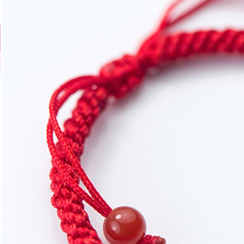 Red string Ruyi bracelet lifestyle image displaying wearable red cord with silver wish-fulfillment charm