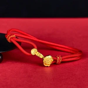 Red string bracelet with Ruyi Fu gold charm, adjustable woven knot design, displayed on red background