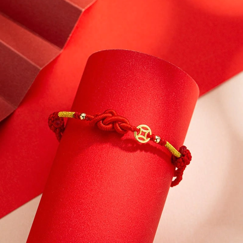 Close Up of Ruyi Knot and Copper Coin Decor on Red Braided Bracelet