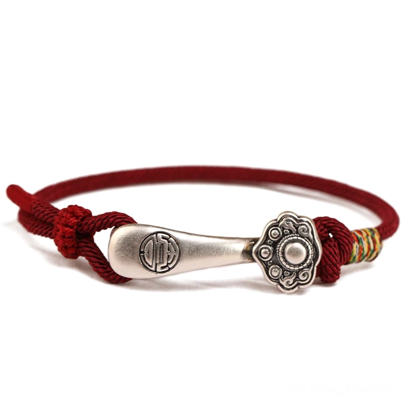 Ruyi stick sterling silver protection bracelet with wine red cord - flat lay view showing detailed silver charm with red knot accents