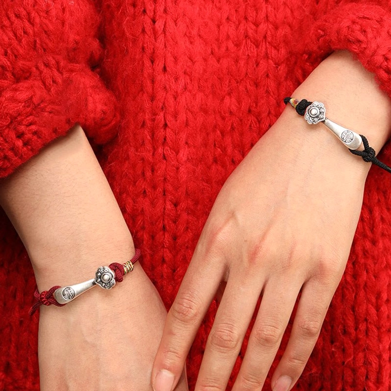 Couple wearing Ruyi stick protection bracelets - red and black cord variants with sterling silver charms showing bracelet styling options