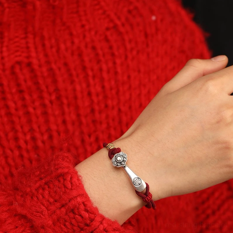 Red string Ruyi charm bracelet worn on wrist - close-up shot showing how protection bracelet looks when worn with silver Ruyi pendant