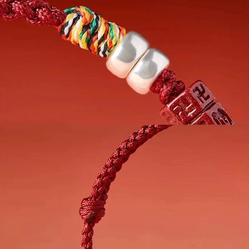 Close-up of Om Mani Padme Hum bracelet components including cinnabar bead, silver accents, and braided red cord