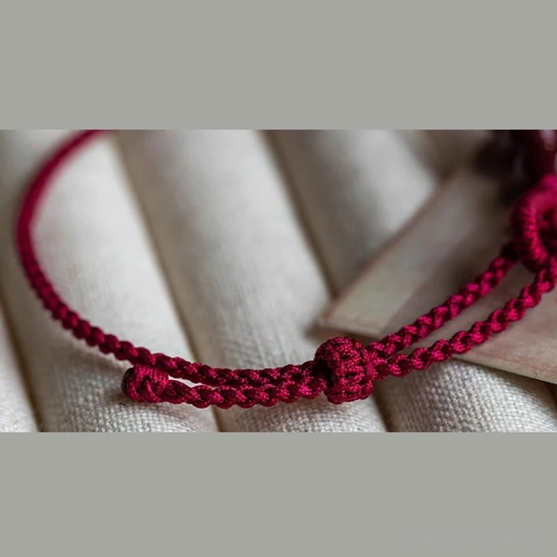 Side view of cinnabar bead braided red string bracelet detail