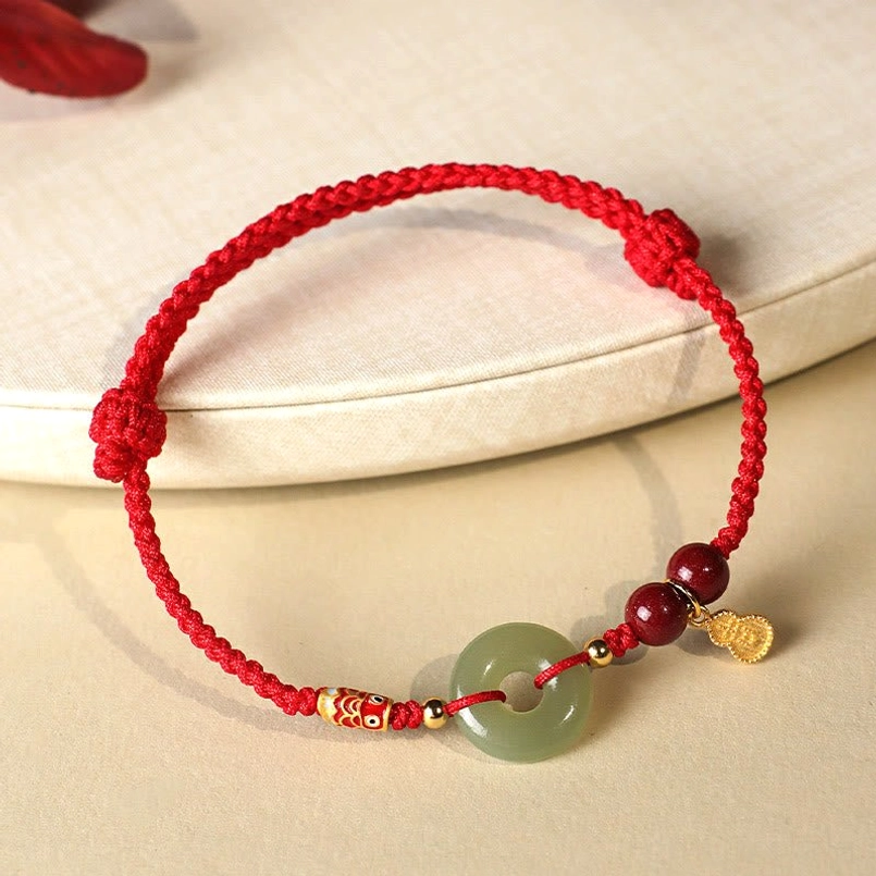 Side view red string Hetian Jade Peace Buckle bracelet on light tray
