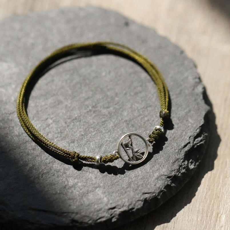 Full circular view of adjustable sterling silver bamboo bracelet with red woven cord
