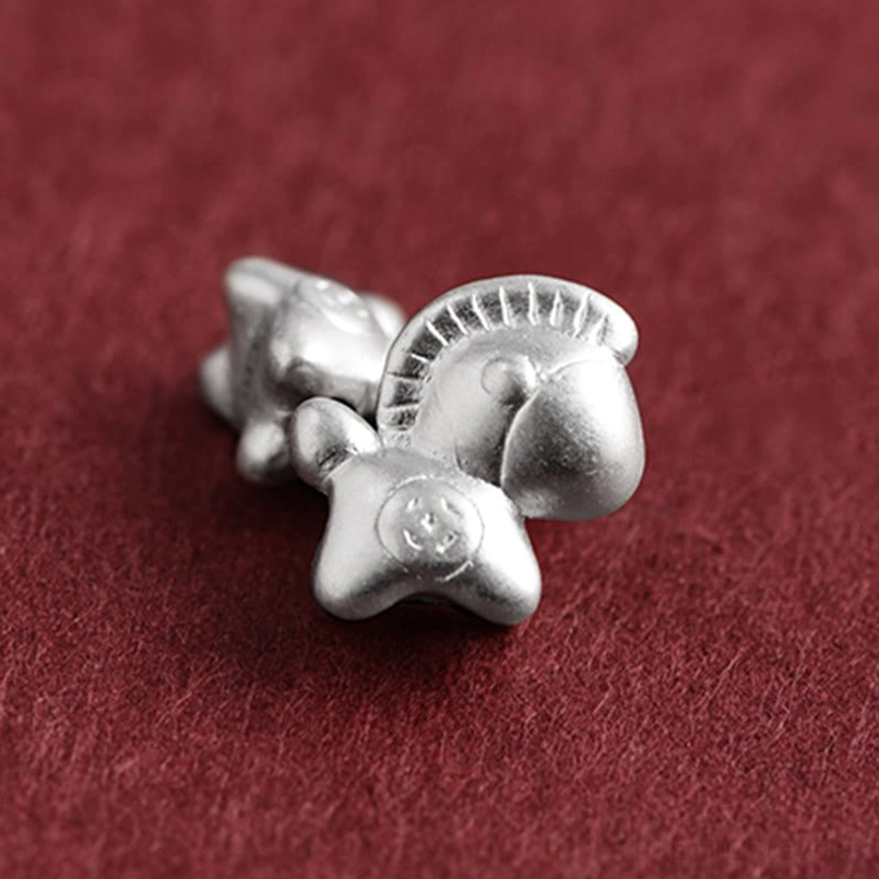 Detailed close-up of 999 sterling silver horse zodiac charm and coin beads on red braided cord