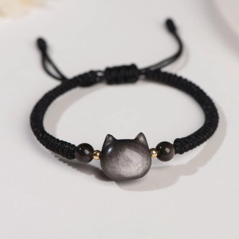 Silver Sheen Obsidian cat bracelet flat lay detail, showing cat pendant and black beaded design with gold accents