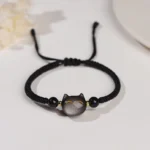 Silver Sheen Obsidian cat protection bracelet with black woven cord and gold accent details, top-down flat lay view