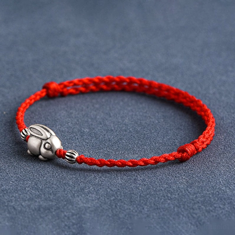 Red string rabbit charm bracelet side profile showing braided cord and silver pendant