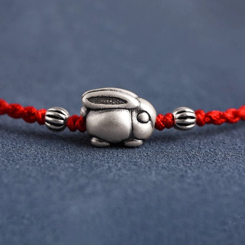 Macro close-up of 999 sterling silver rabbit charm with accent beads