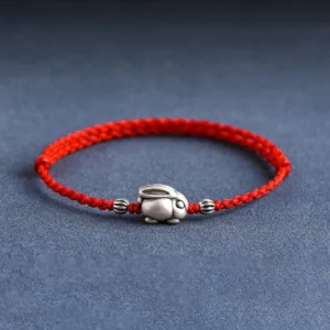 999 sterling silver rabbit red string bracelet front view flat lay on dark blue fabric