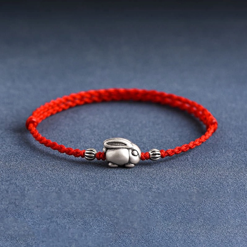 999 sterling silver rabbit red string bracelet front view flat lay on dark blue fabric