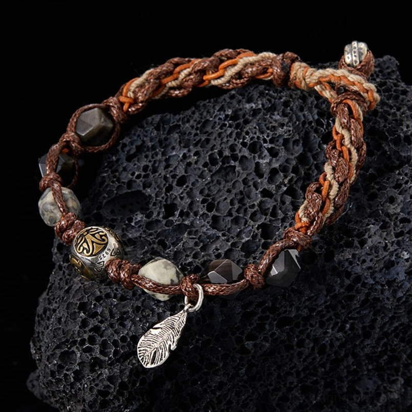 close up of silver sheen obsidian red string bracelet with carved silver bead