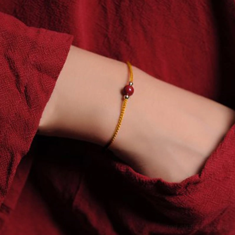 Minimalist 1 cinnabar bead yellow string bracelet close up on wrist