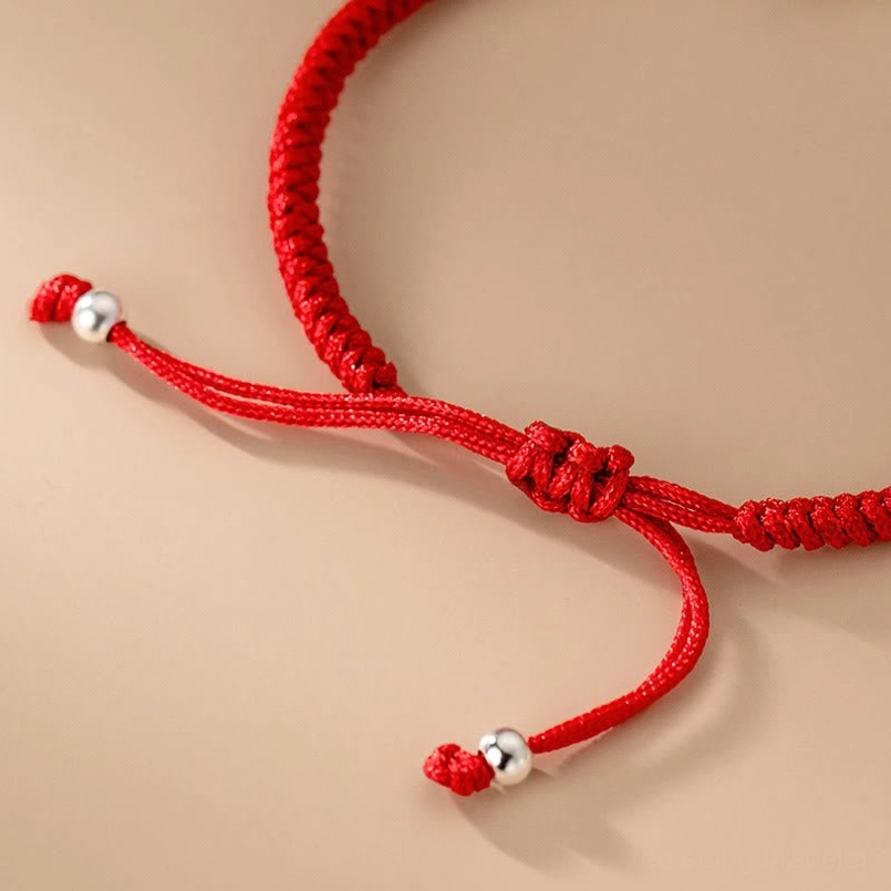 Top view of sliding knot adjustable closure of Fu charm red string bracelet