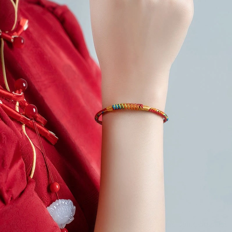 Slim multicolor red string bracelet worn on human wrist lifestyle shot