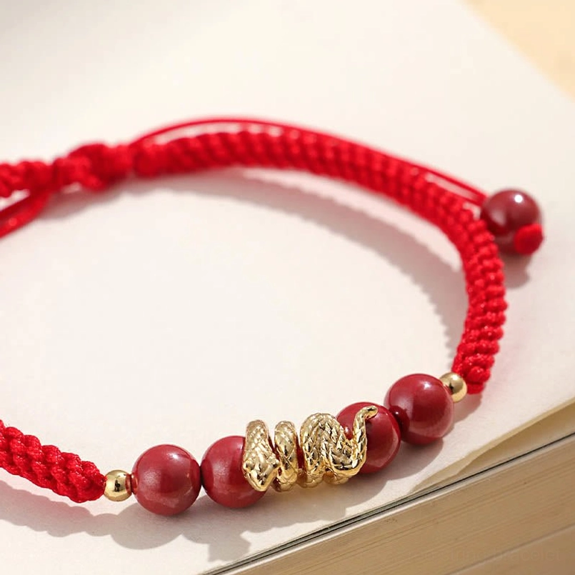 Close up view of snake charm and cinnabar beads on red string bracelet
