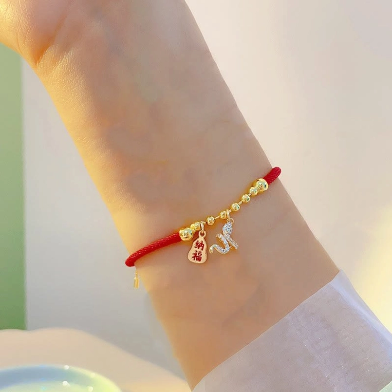 Snake fu character red string bracelet close-up wrist side view with white sleeve